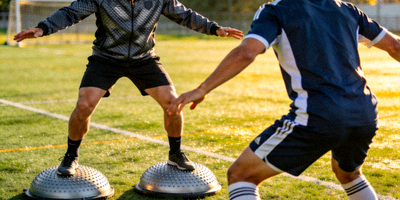 教练演示如何正确使用平衡半球进行足球运动员的协调性训练