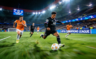 欧洲冠军联赛直播画面，球员在绿茵场上带球突破