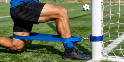 运动员使用蓝色阻力训练带进行足球专项腿部力量训练