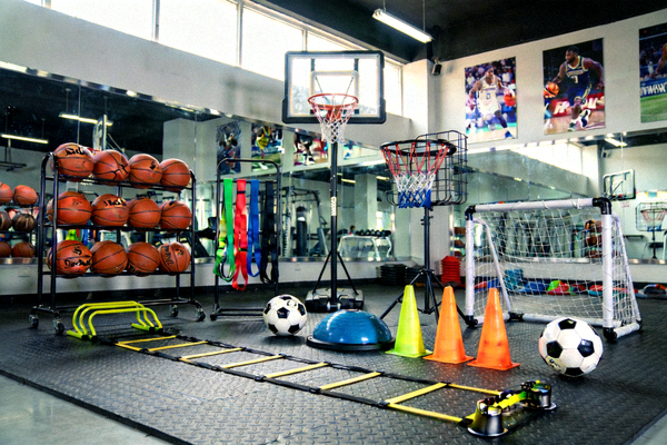 专业体育器械助力训练提升，展示多种篮球和足球训练器材在健身房场景中